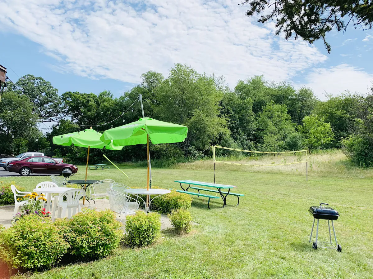 Open lawn with garden umbrellas and picnic tables on a summer day