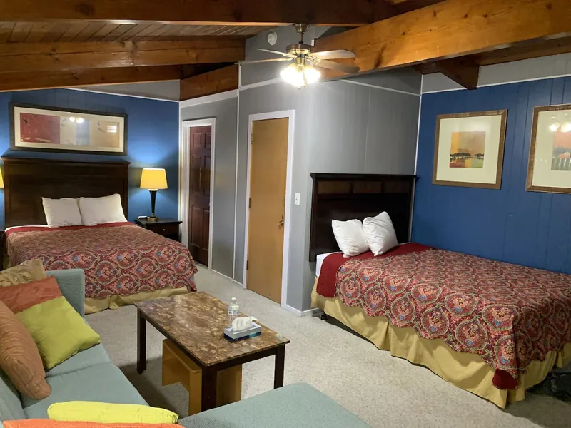 Family suite with two beds, a blue wall and a sofa seating area